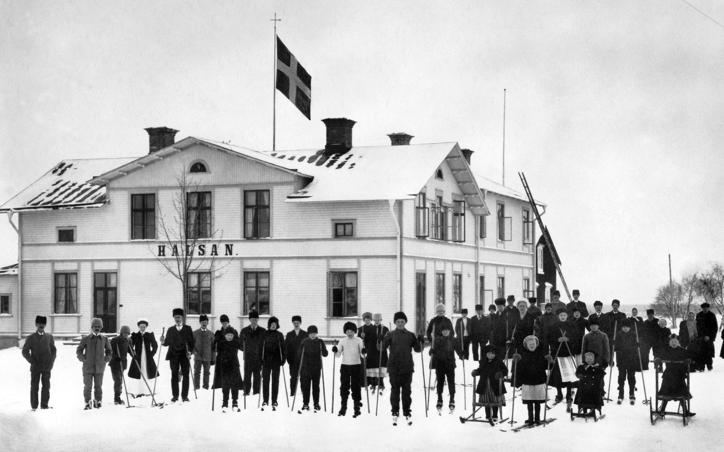 Folksamling framför hus med namnet Hälsan.