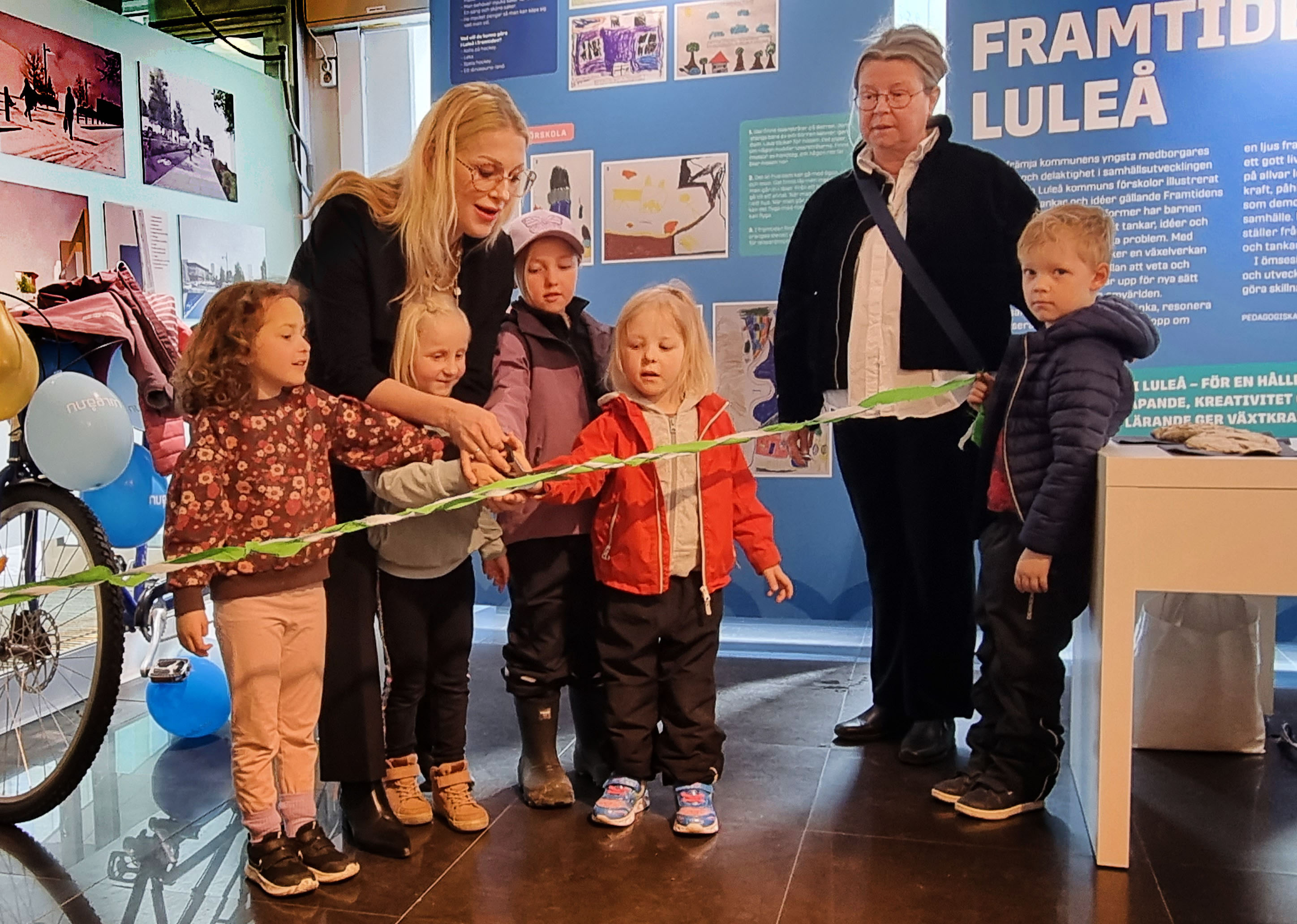 Förskolebarn klipper bandet till utställningen tillsammans med Emma Engelmark och Annica Backman.