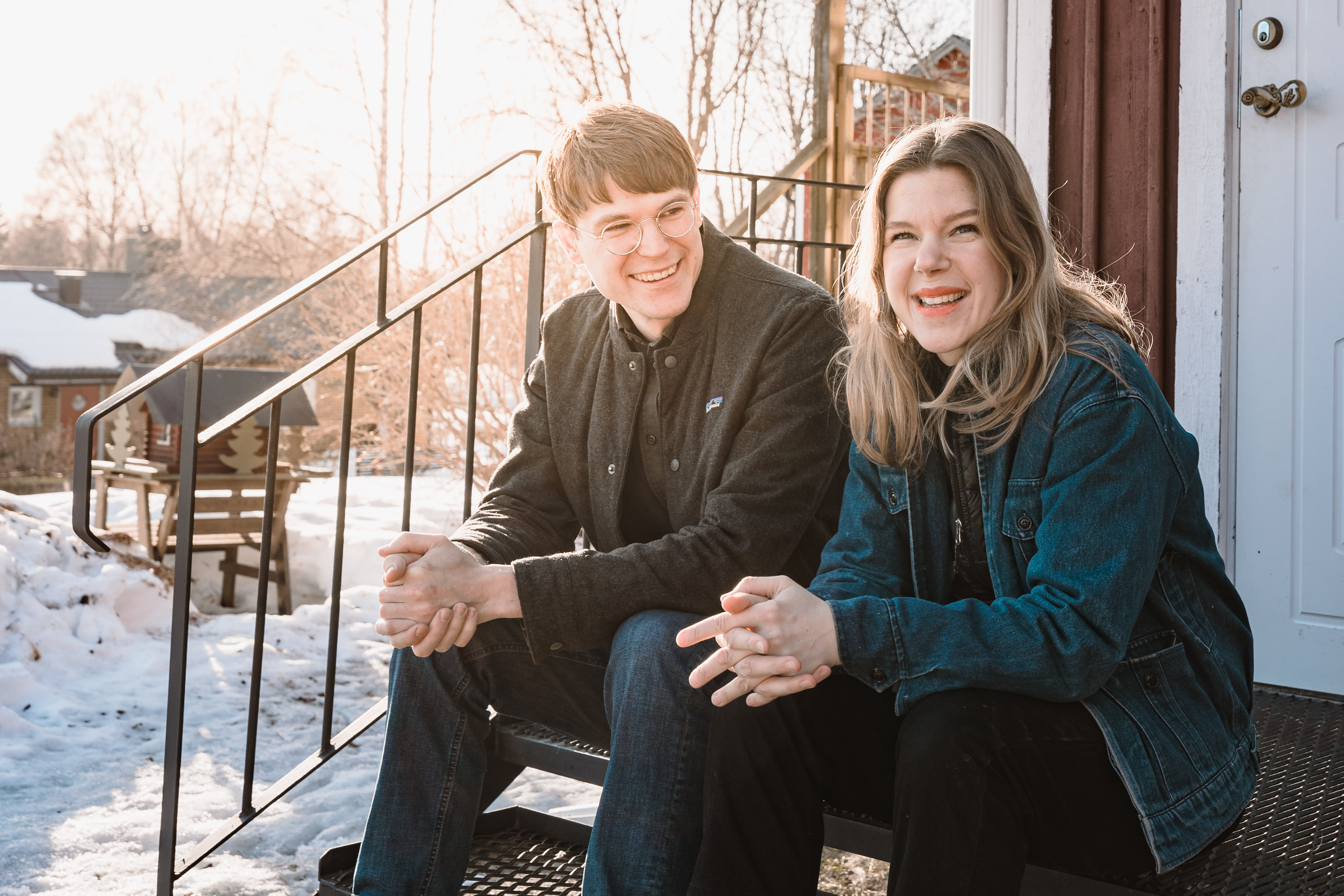 Oscar och Jenny sittandes på farstubron till sin röda trävilla i vårvintersolen