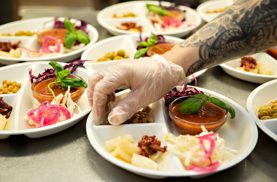 Kock lägger upp grönsaker på fat