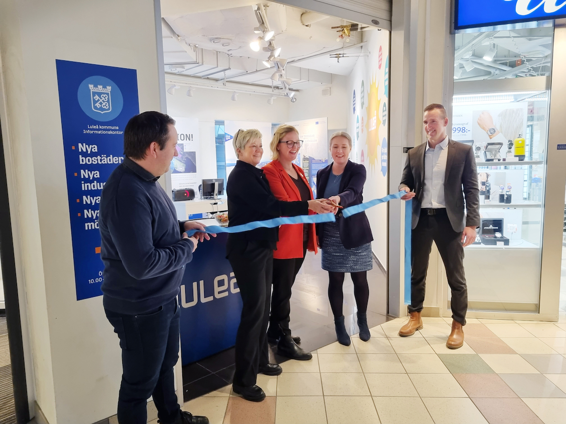 Flera personer klipper av ett band inne i Smedjan.