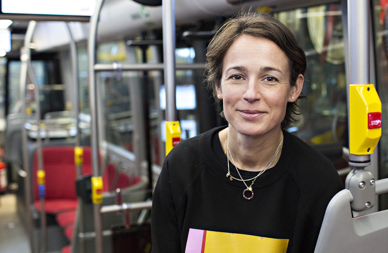 En kvinna står inne i en buss.