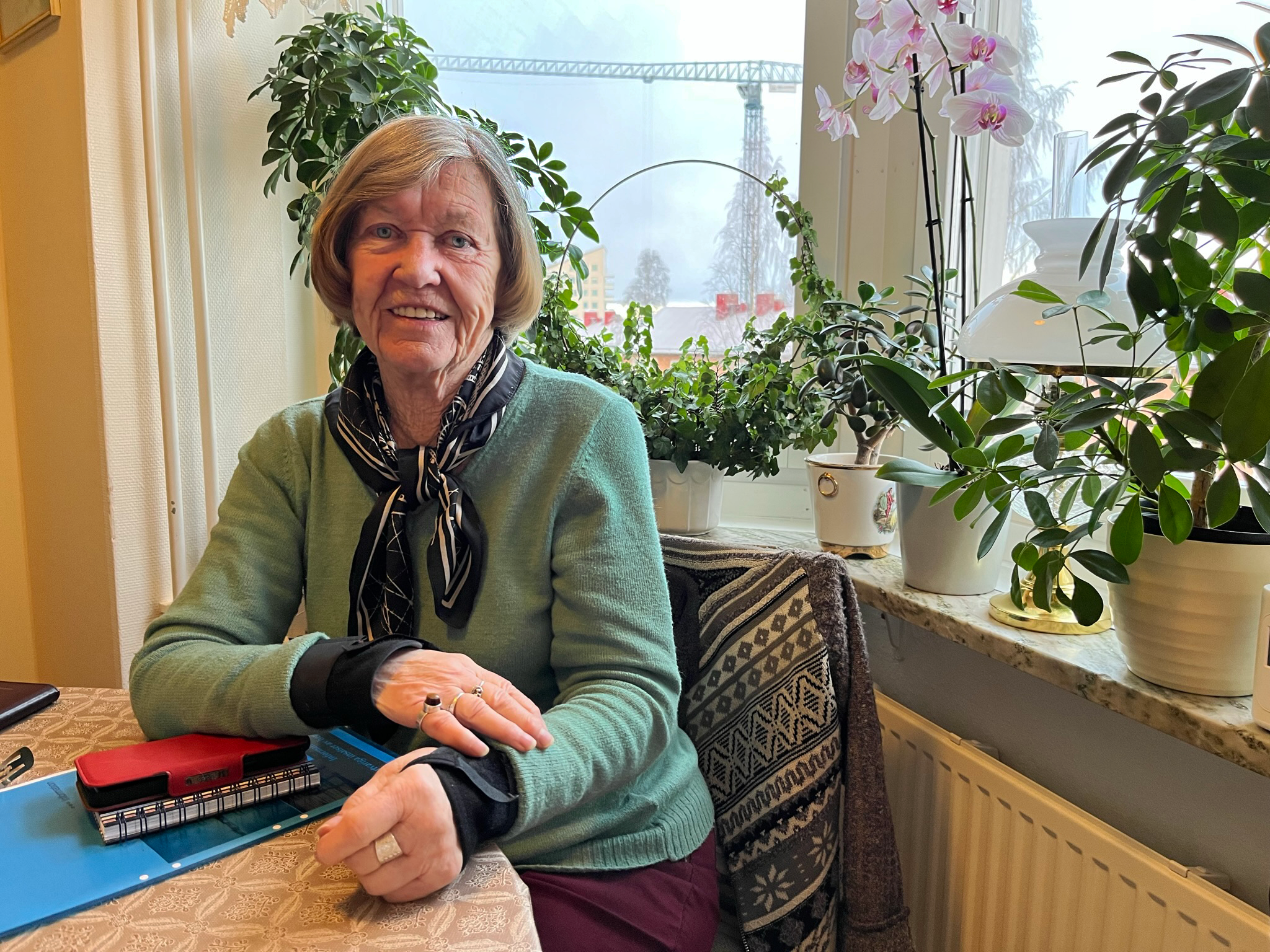 Margareta sitter framför ett fönster. Hon ler.