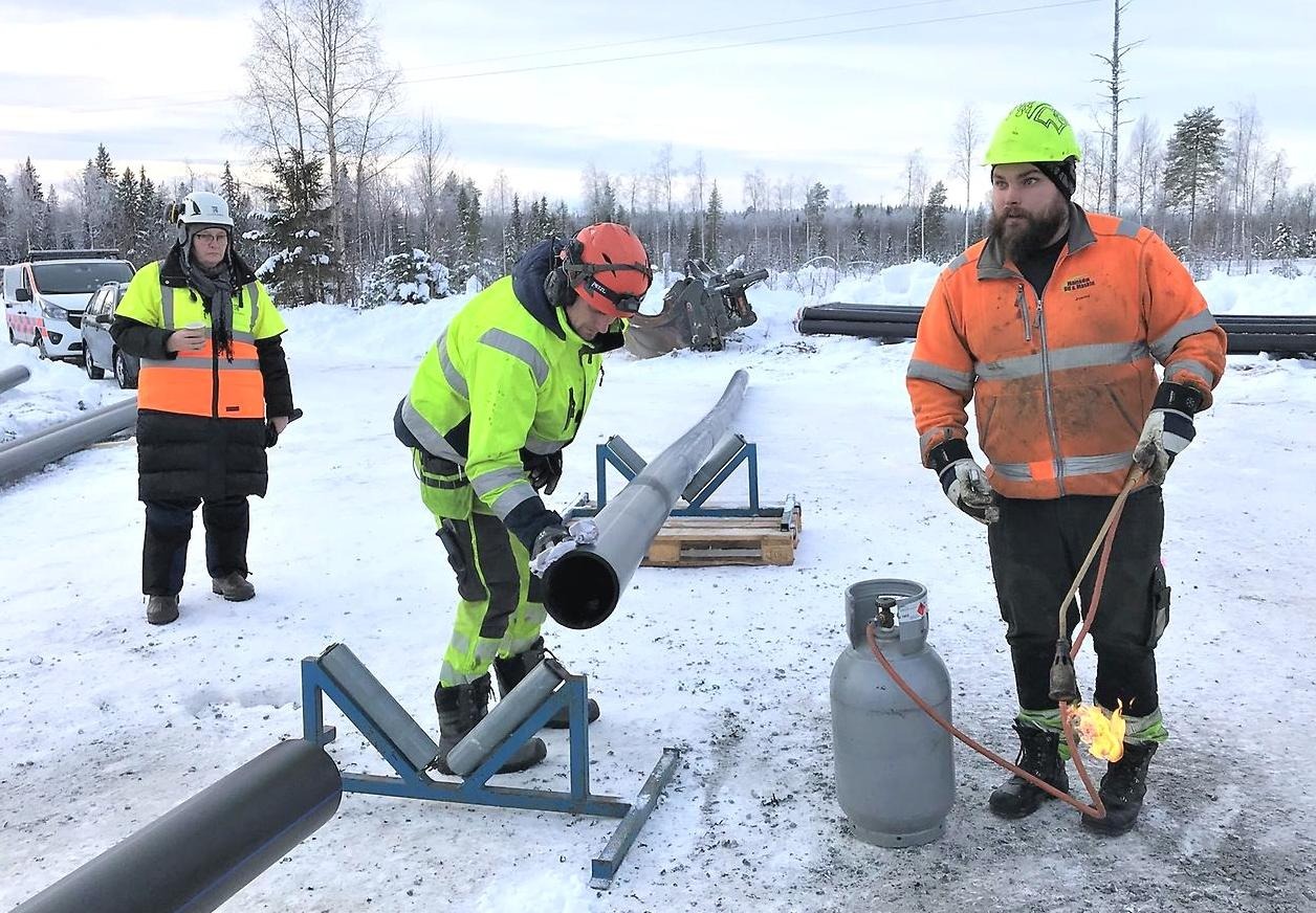 Anja Johansson, ordförande i stadsbyggnadsnämnden studerar när två anläggningsarbetare arbetar med vattenledning vid invigningen av överföringsledningen till Råneå