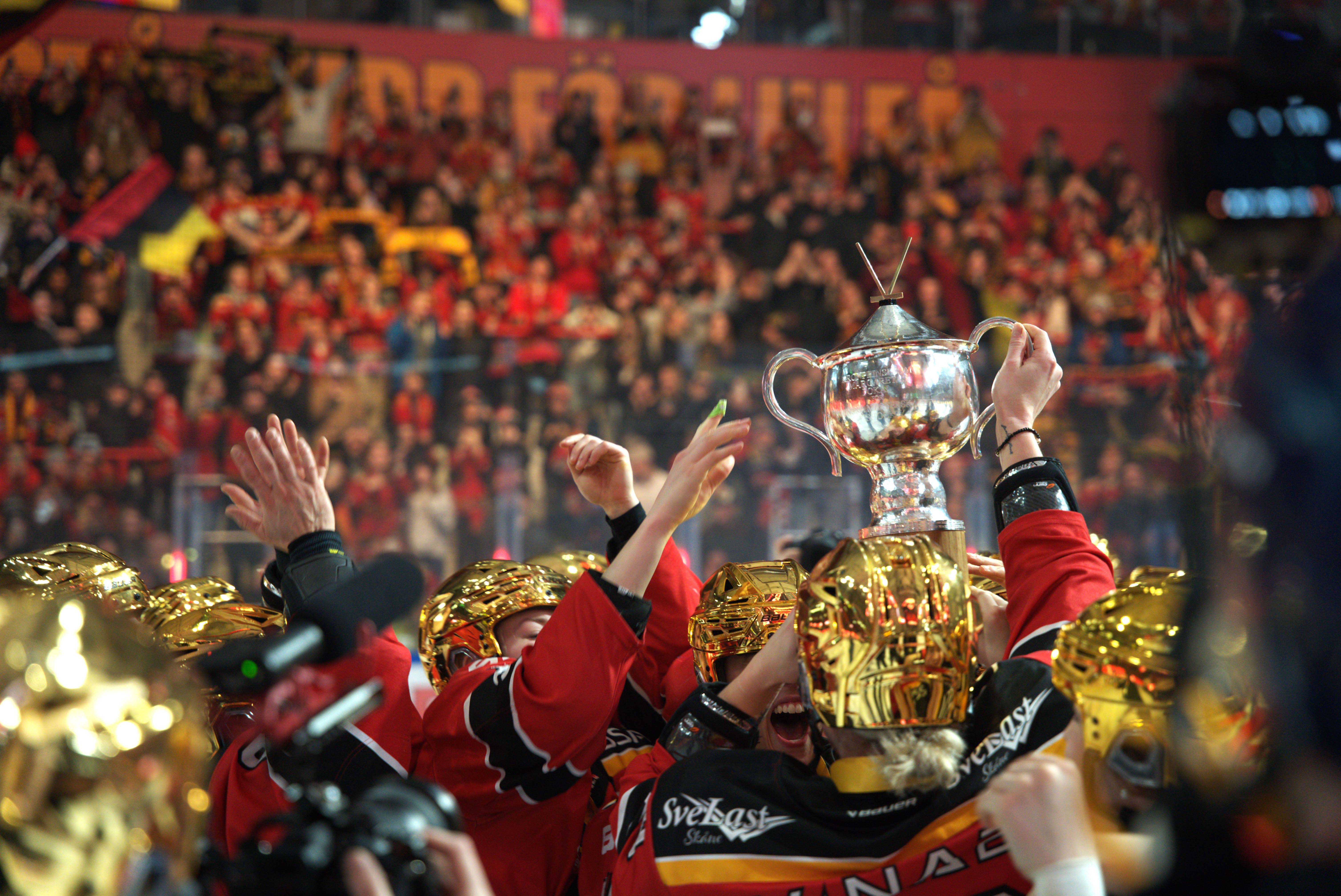 Hockeyspelarna håller en silvrig buckla i luften.
