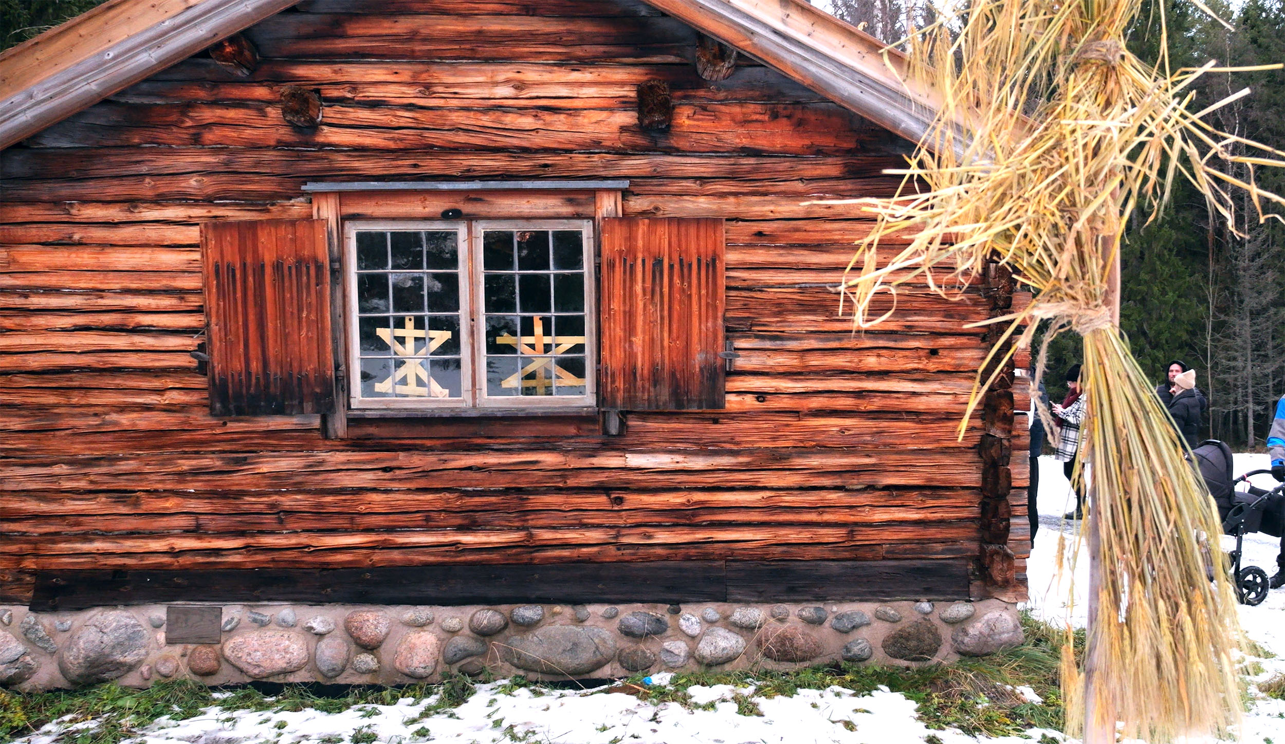 Ett timrat hus med ett julkors i fönstret. Det är en av de gamla jultraditionerna som tas upp på visningen.
