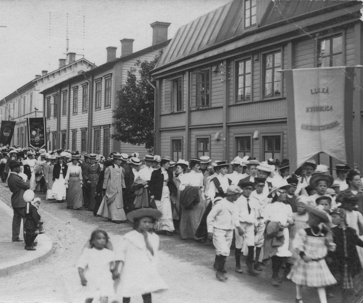 Svartvitt foto där kvinnor i hatt marscherar genom Luleå.