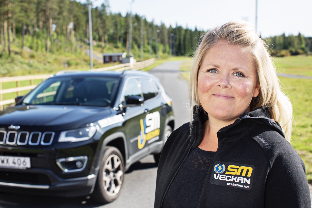 Sandra Ottosson står vid en bil med texten SM-veckan på.