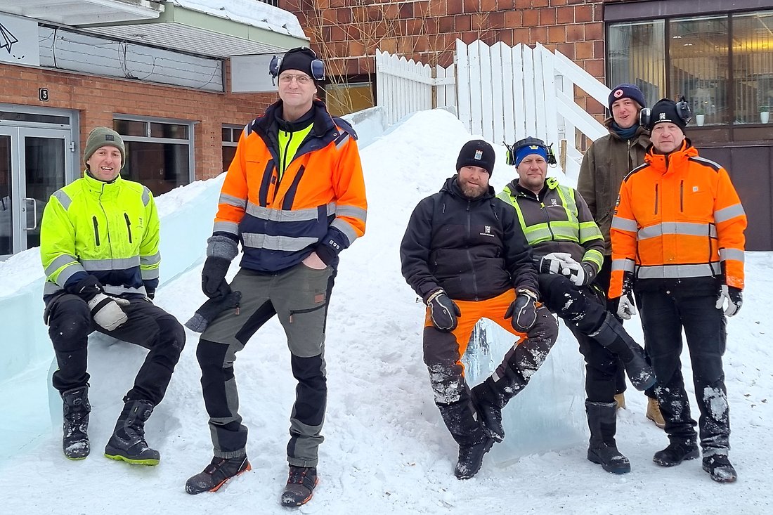 Del av de som byggt isrutschkanan står framför sitt bygge
