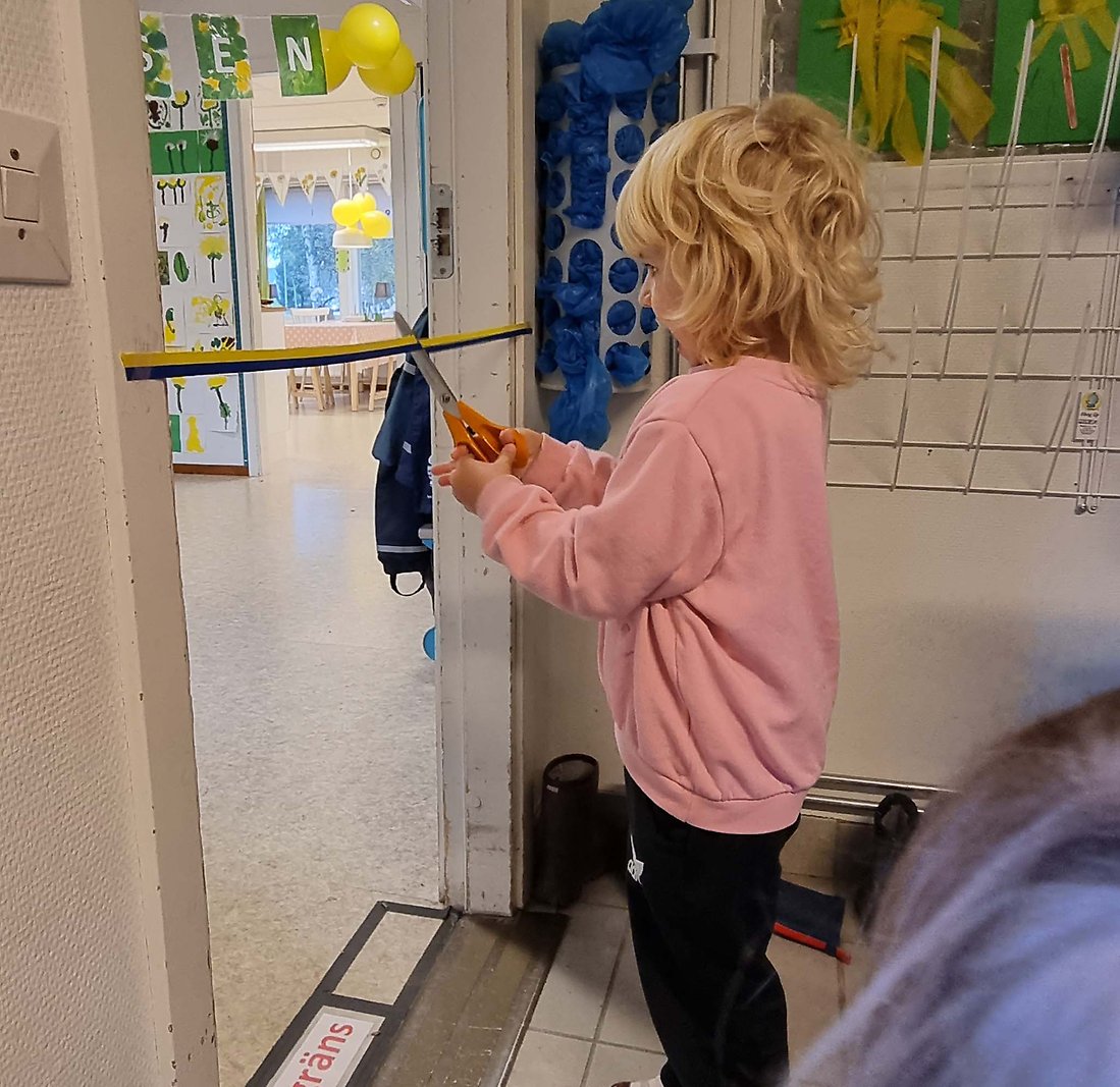 Barn klipper band till sin avdelning på namngivningsceremonin