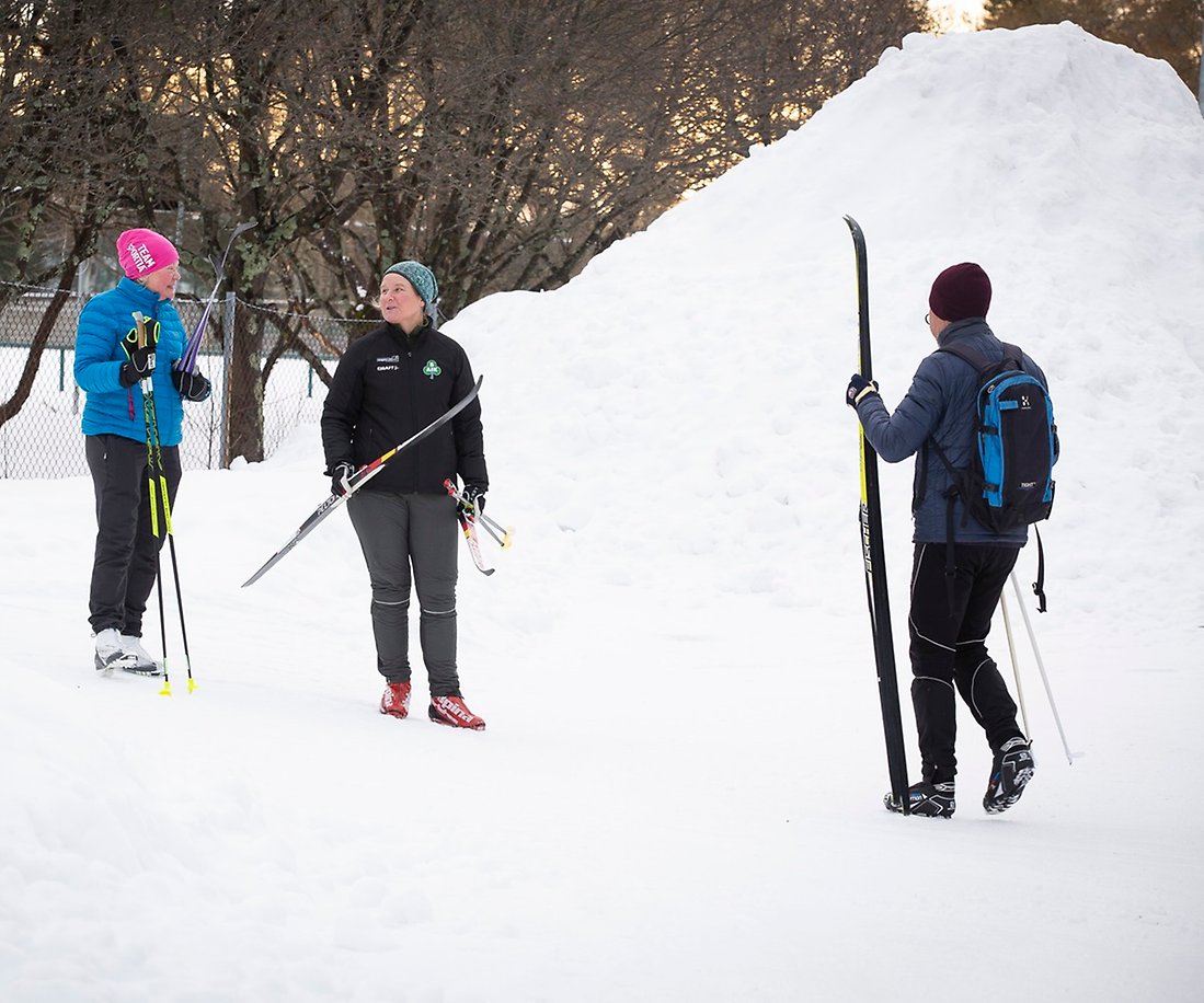 Tre personer på skidor i snö.