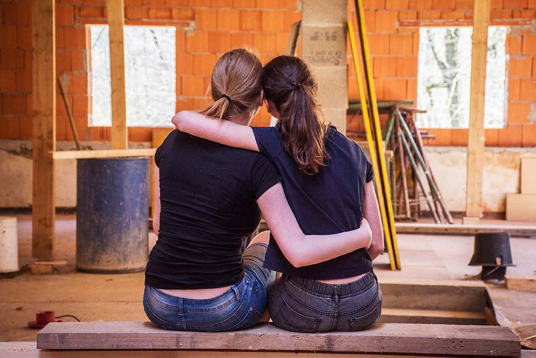 ryggen på två kvinnor som tittar på en vägg