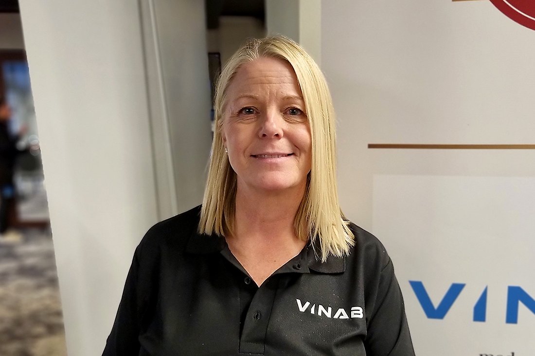 Blond kvinna med Vinabs emblem på bröstet