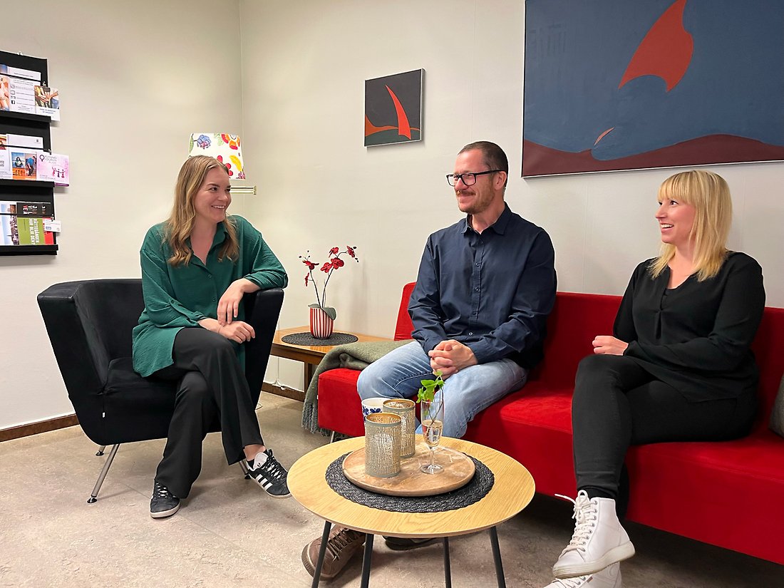 Tre personer sitter i en soffgrupp.