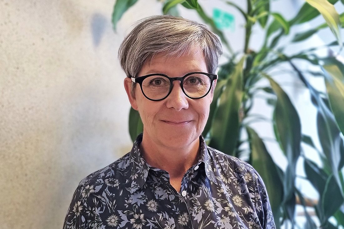 Leende kvinna med kort hår och glasögon