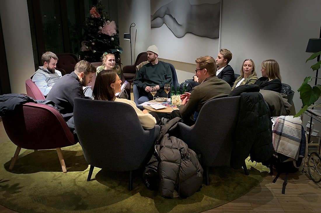 En grupp med unga människor som sitter i fåtöljer och umgås