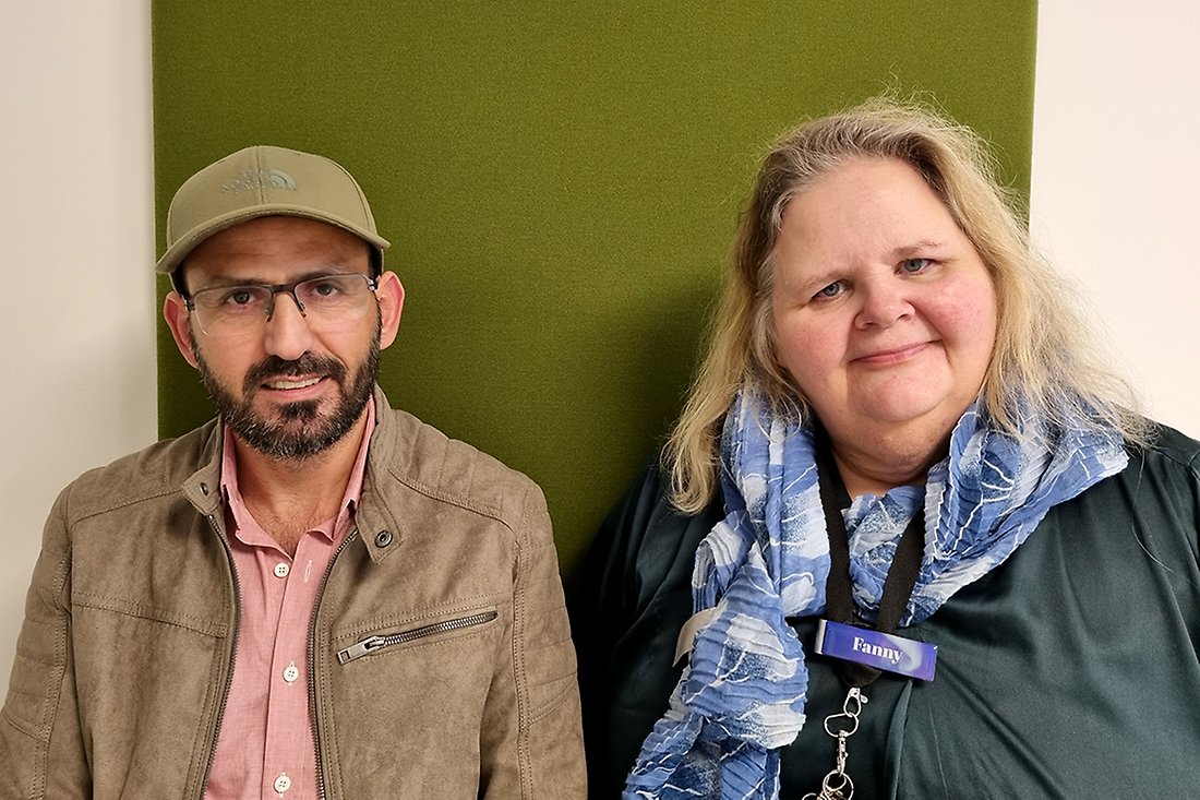 Leende man med keps och leende kvinna