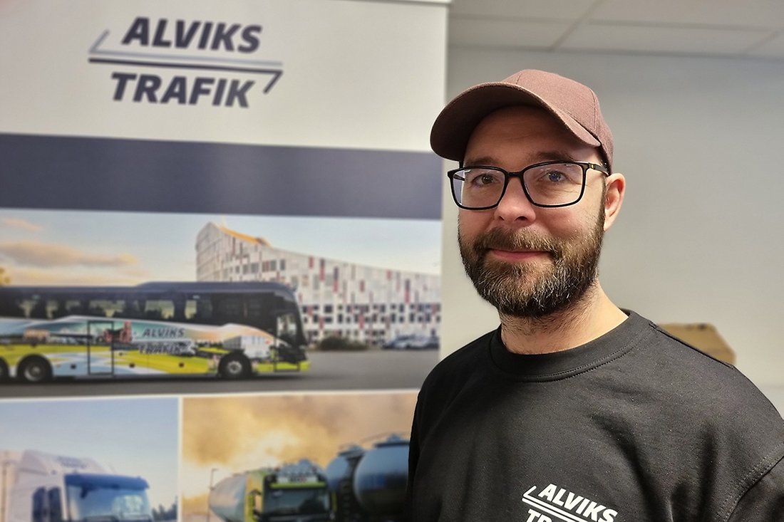Leende man i keps med emblem på tröjan som säger Alviks trafik