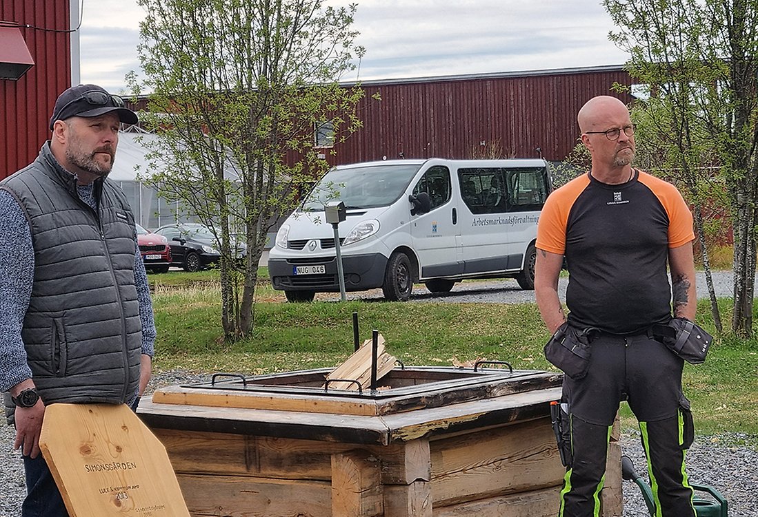 Verksamhetsansvariga vid Simonsgården står vid en eldstad ochberättar om verksamheten